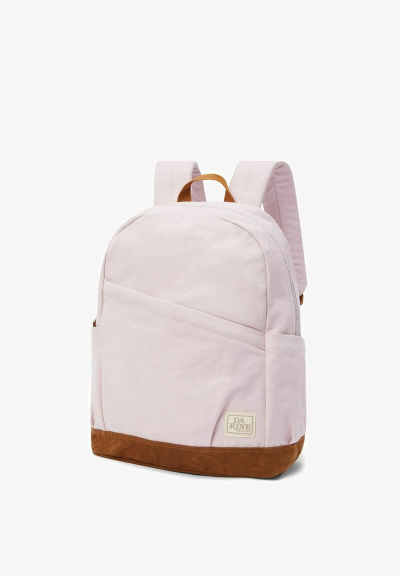 Sac à dos en toile rose avec un fond en suède marron, doté de bretelles ajustables, d'une poche avant et d'un patch de marque sur le côté inférieur.