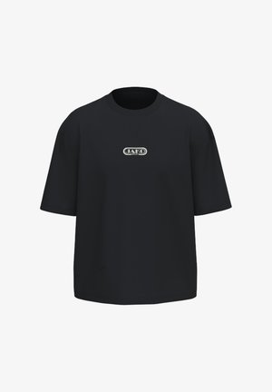 Schwarzes oversized T-Shirt mit kurzen Ärmeln, rundem Ausschnitt und kleinem weißen Logo mit der Aufschrift "JAKO SPORT" zentriert auf der Brust.
