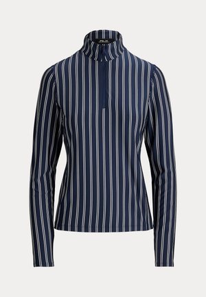 Chemise bleu marine à manches longues avec des rayures verticales blanches et une courte fermeture éclair sur le devant sous un col montant.