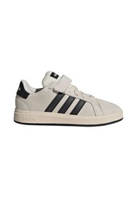 Beige Adidas sneaker med sorte striber, velcrolukning, snørebånd og beige sål med sort kant, sideblik.