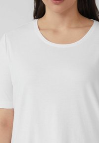 White cotton t-shirt with a round neckline and short sleeves, smooth texture, and no visible patterns or accents.