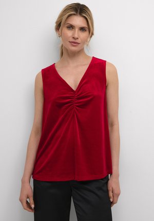 Top sans manches en velours rouge avec un décolleté en V et un détail froncé au centre, présentant une silhouette fluide et une texture lisse.