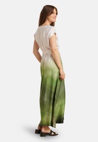Maxi-jurk met een gradient ontwerp van wit naar groen, gemaakt van een soepele stof. Het heeft korte mouwen en een taille riem, met zijsplitsen.