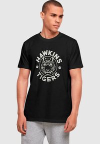 ABSOLUTE CULT STRANGER THINGS - HAWKINS TIGER - Triko s potiskem - black