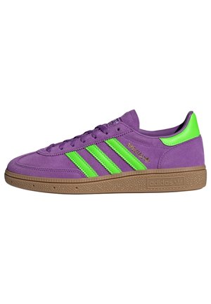 Baskets Adidas en daim violet avec des bandes vertes, languette de talon verte, semelle en caoutchouc texturée marron et logo "Spezial" doré sur le côté.