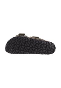 Semelle en caoutchouc noir avec un motif de semelle ondulé. La tige présente un tissu vert avec un design texturé et deux bandes velcro pour la fermeture.