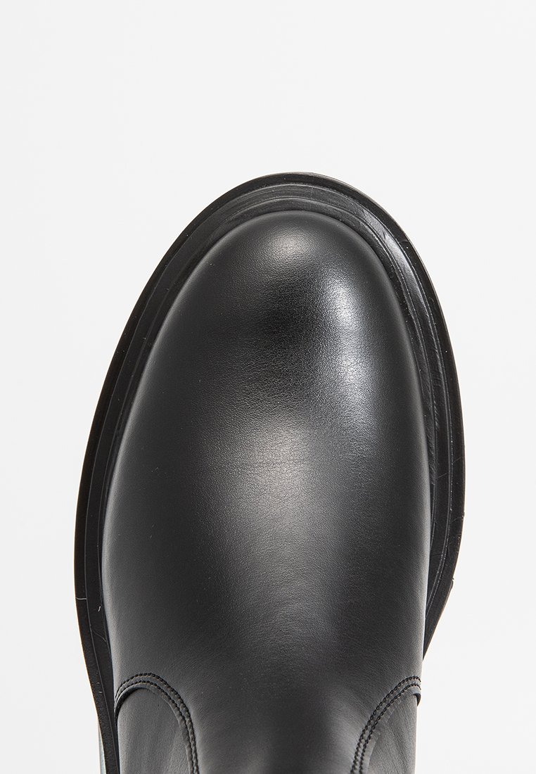 Zwarte leren laars met een ronde neus en een gladde textuur. Bevat subtiele stikdetails en een duurzame rubberen zool.