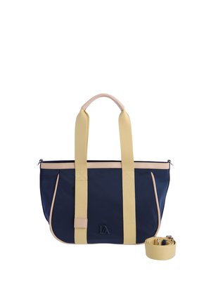 Bolsa tote azul marino y beige con asas largas beige y correa de hombro desmontable, con un pequeño logo negro en la parte delantera.