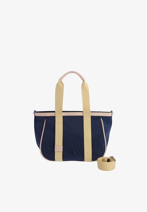 Bolsa tote azul marino y beige con asas largas beige y correa de hombro desmontable, con un pequeño logo negro en la parte delantera.