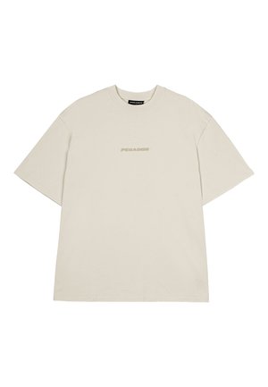 Beige t-shirt met korte mouwen, gemaakt van katoen. Het heeft een ronde hals en een subtiele, gecentreerde tekst "PEGADOR" in lichter beige op de voorkant.