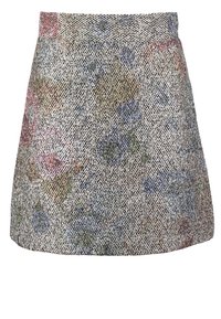 Jupe courte en tissu texturé, présentant un motif floral multicolore dans des tons de bleu, vert et rose sur un fond clair.