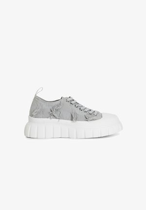 Baskets en toile grises avec une texture vieillie, dotées d'une épaisse semelle blanche, d'un bout rond et d'œillets métalliques avec lacets.