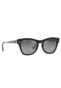 Occhiali da sole con montatura in plastica nera a forma di occhio di gatto, lenti grigie sfumate, accentuazioni in argento sulle tempie e logo impresso sulla montatura.