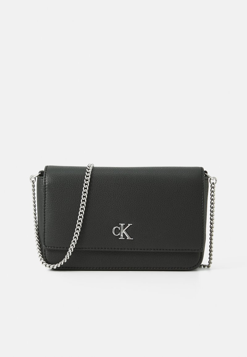 Bolso bandolera de imitación cuero negro con una correa de cadena, forma rectangular, acento de logo plateado y superficie texturizada. Diseño compacto y elegante.