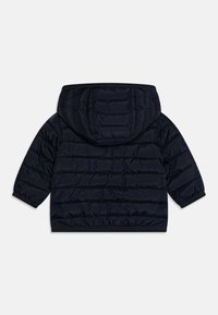 Chaqueta acolchada de color azul marino con capucha, que cuenta con un diseño de acolchado horizontal, puños elásticos y un dobladillo ligeramente ajustado para mayor calidez.
