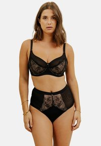 Ensemble de lingerie noire comprenant un soutien-gorge et une culotte taille haute. Le soutien-gorge présente des panneaux transparents et des détails en dentelle florale ; la culotte inclut des accents en dentelle similaires.