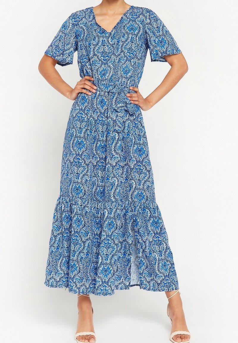 Modrá maxi šaty se vzorem, krátkými rukávy, výstřihem do V a vrstveným spodním lemem. Obsahují složité vzory v různých odstínech modré.