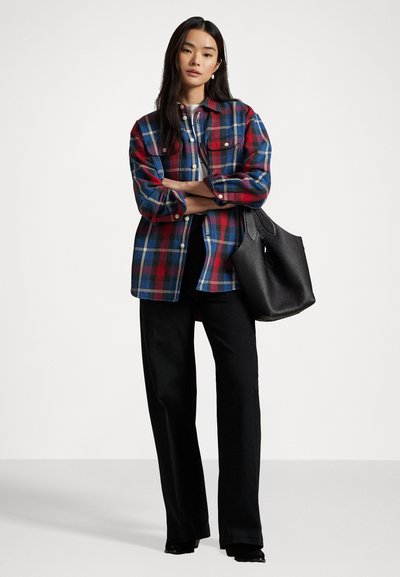Red and blue plaid shirt with two chest pockets, black wide-leg pants, and a textured black tote bag. White background.