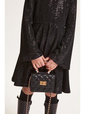 Abito nero con paillettes e maniche a campana, abbinato a una piccola borsa nera trapuntata con una chiusura dorata e una tracolla con perline.