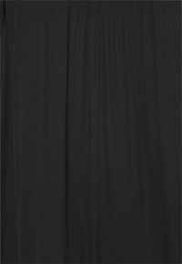 Sort gardin med lodrette foldelinjer, der skaber subtil tekstur og folder.