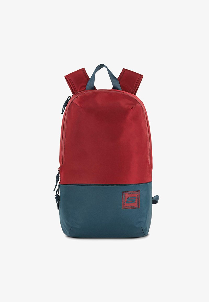 Mochila de poliéster roja y azul con correas de hombro acolchadas, compartimentos dobles con cremallera y un parche de logo en el frente. Textura suave, forma rectangular.