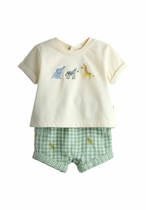 Crèmekleurig T-shirt met korte mouwen met geborduurde olifant, zebra en giraffe, gecombineerd met groene geruite korte broek met kleine giraffenprints.
