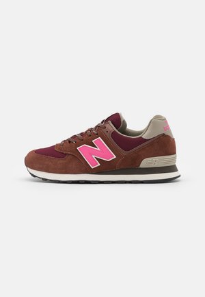 Baskets New Balance marron et bordeaux avec logo "N" rose, languette beige au talon et semelle blanche et noire, vues de profil.