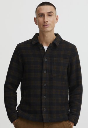 Button-up shirt in dark fabric, featuring a plaid pattern in dark blue and brown. It has a collared neck and a front pocket.