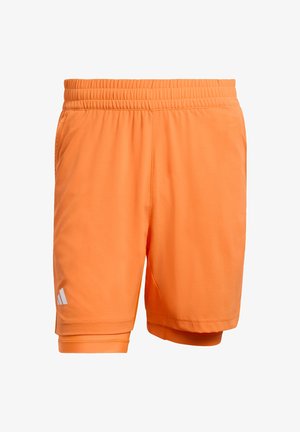Orange athletic shorts with an elastic waistband, smooth texture, and white logo detail on the left side. Features a regular fit.