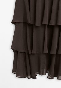 Abito in chiffon scuro a strati, con un design fluido, caratterizzato da numerosi volant e una texture morbida e trasparente.