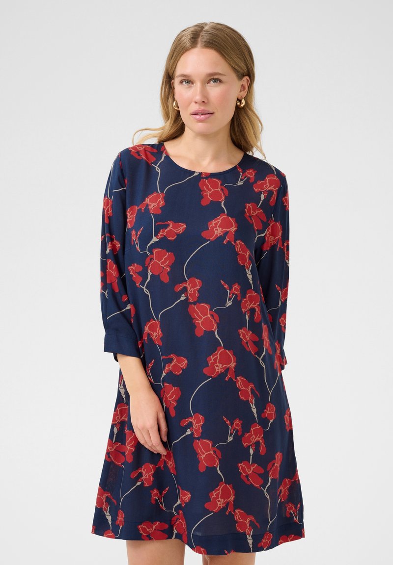 Vestido azul marino con estampado floral rojo, escote redondo y mangas tres cuartos. Tejido ligero y fluido con un corte relajado.
