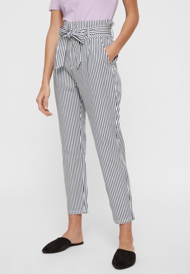 Pantalon rayé noir et blanc à taille haute, ceinture à nouer et poches latérales. Le tissu semble léger et lisse.