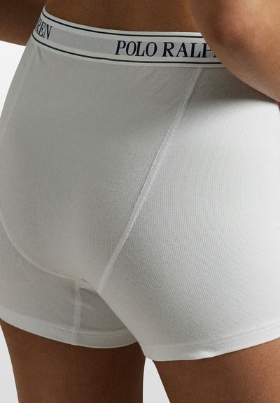 Vita bomullsboxershorts med ribbad struktur och en figurnära design. Har ett marinblått resårband med texten "POLO RALPH LAUREN".