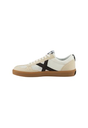 Zapatilla deportiva blanca y beige con parte superior de malla transpirable, detalle del logo en marrón oscuro y suela de goma. Presenta un cierre con cordones.