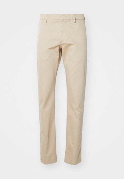 Beige bomulds chinos med lige pasform, der har flad front og bæltestropper. Glat tekstur og minimal detaljering.