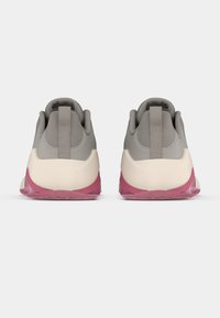 Graue Sportschuhe mit einer glatten Oberseite, strukturierten Einsätzen und einer pinken transparenten Sohle. Mit einer Lasche an der Rückseite für einfaches Anziehen.