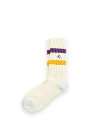 Calcetín crema simple con puntera gris, parte superior acanalada con franjas moradas y amarillas y un pequeño logo circular.