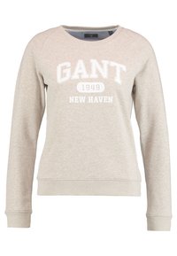 Sudadera de color beige claro con cuello redondo, mangas raglán y textura cepillada. Presenta texto en blanco: "GANT 1949 NEW HAVEN."