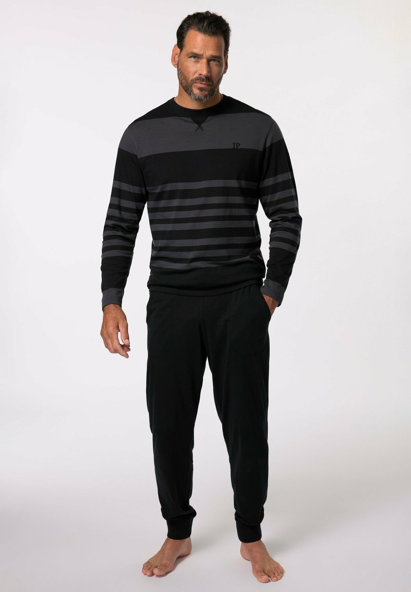 Chemise rayée noire et grise à manches longues avec un col rond, associée à un pantalon noir. Le tissu semble doux et confortable.