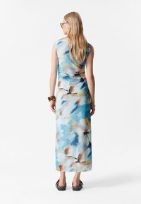 Maxikleid aus leichtem Stoff mit einem Aquarell-Blumenmuster in Blau, Orange und Cremetönen; ärmellos mit einem taillierten Oberteil und fließendem Rock.