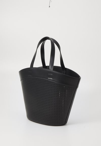 Svart perforerad handväska med strukturerad form, två robusta handtag och en slät övre kant. Har en modern design och en texturerad yta.