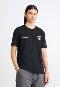Melnas īsām piedurknēm t-krekls ar apaļu kakla izgriezumu, ar baltu "Champion" logotipu uz krūtīm un izšūtu tekstu. Mīksts audums, brīvs piegriezums.