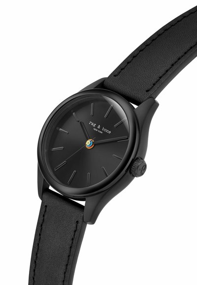 Czarny analogowy zegarek na rękę z minimalistycznymi znacznikami godzin, czarnym skórzanym paskiem i logo "rag & bone" na tarczy.