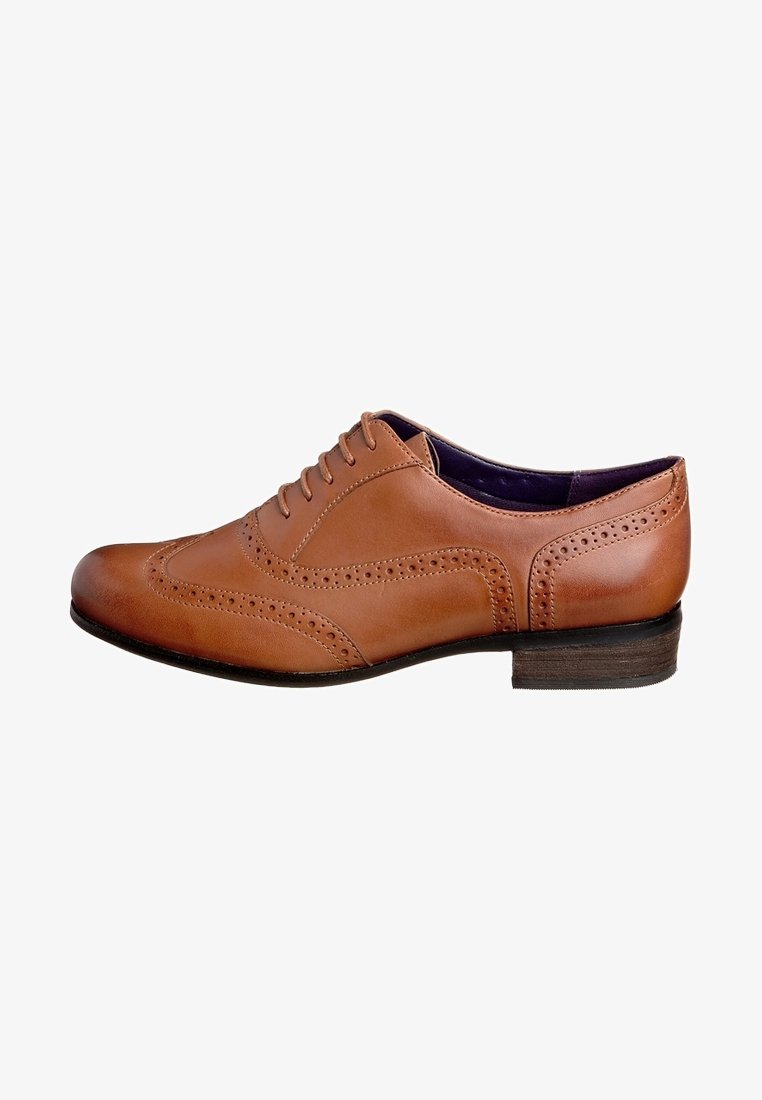 Chaussure brogue pour homme en cuir marron avec design à bout ailé, lacets et petit talon en bois empilé, vue latérale sur fond blanc.