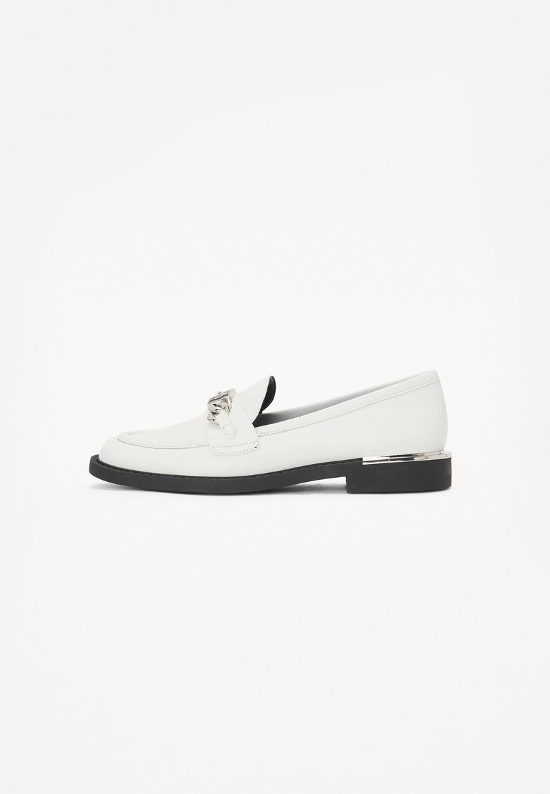 Weiße Lederloafers mit einer niedrigen schwarzen Sohle, silberner Hardware-Akzent auf der Vorderseite und einem glatten, strukturierten Design.