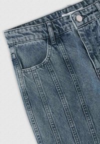 Jeans in denim a lavaggio scuro con dettagli di cucitura verticale, tasca frontale, chiusura con bottone in metallo e classica struttura a cinque tasche.