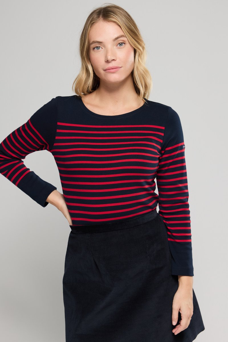 Mørkeblå og rødstribet bluse med lange ærmer og rund halsudskæring, parret med en sort fløjlssort kjole. Har en behagelig pasform og blød tekstur.