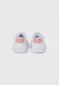 Λευκά αθλητικά παπούτσια με ομαλή συνθετική επάνω επιφάνεια, επενδεδυμένο γιακά και ροζ τονισμένο τακούνι. Διαθέτουν το λογότυπο της μάρκας στη φτέρνα. Εξωτερική σόλα από καουτσούκ.