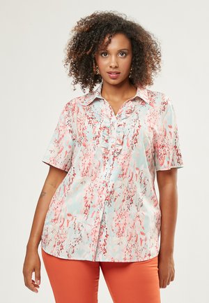Short-sleeve button-up shirt in a light blue fabric featuring a pink floral pattern and ruffled placket detail.