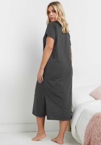 Grå, kortärmad, maxiklänning med sidoflikar, tillverkad av mjukt, elastiskt tyg. Golvlång med en avslappnad passform och en slät yta.